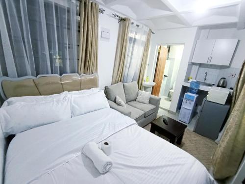 a bedroom with a large white bed and a couch at Cities bnbs in Gatunga