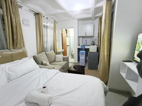 a bedroom with a white bed and a living room at Cities bnbs in Gatunga