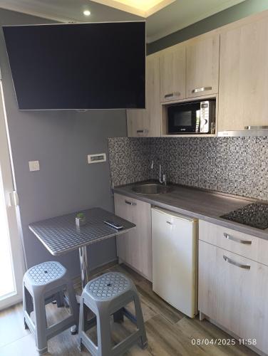 a kitchen with a table and two stools in it at Villa Sun Budva in Budva