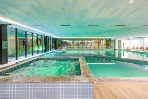 a large indoor swimming pool in a building at Gran Paradiso Campos do Jordão By Ventura OFICIAL in Campos do Jordão