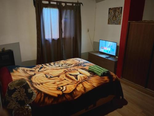 a bedroom with a tiger patterned bed with a television at Dpto BBB in Zapala
