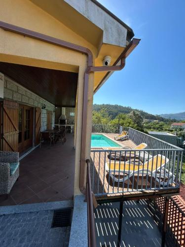 a balcony of a house with a swimming pool at Casa Amarela da Caniçada in Vieira do Minho