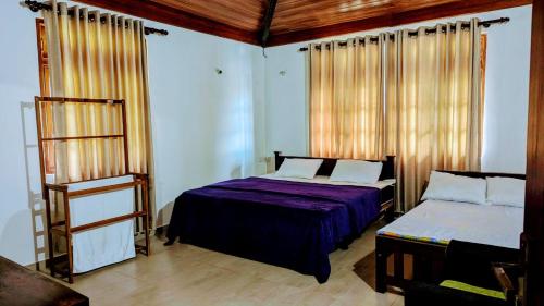a bedroom with two beds and a wooden ceiling at Tranquil Rest in Nikawatawana