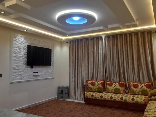 a living room with a couch and a television at diki ksar sghir in Oulad Akkou