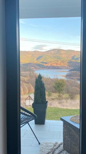 a view of a lake from a porch with a bench at Vila Luka i Ana - Apartman Luka in Zaovine