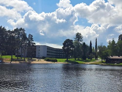 a building next to a body of water at Kylpylä-Hotelli, kahden huoneen huoneisto in Ikaalinen