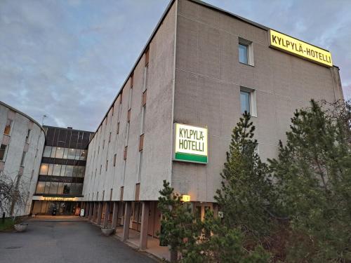 a building with a sign on the side of it at Kylpylä-Hotelli, kahden huoneen huoneisto in Ikaalinen