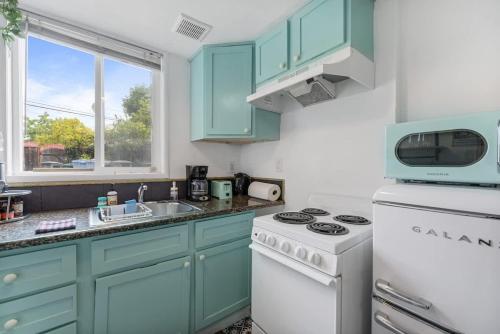 a kitchen with blue cabinets and a white stove top oven at Garden Oasis Cozy Home Near Bart Shop with Parking in Berkeley