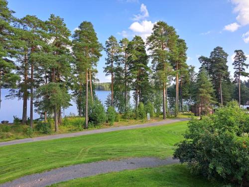 a golf course with a view of the water and trees at Kylpylä-Hotelli, kahden huoneen huoneisto in Ikaalinen