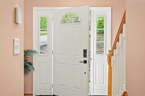 a white door in a room with a staircase at Lakeview Retreat w Kayaks Game Room Firepits Gated Community w Lake Beach Access in East Stroudsburg