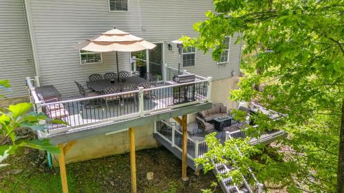 a deck with chairs and an umbrella on a house at Lakeview Retreat w Kayaks Game Room Firepits Gated Community w Lake Beach Access in East Stroudsburg