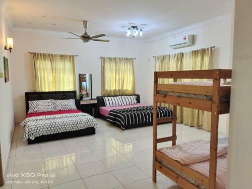 a bedroom with two beds and a bunk bed at MyGemilang Homestay Bentong in Kampong Sungai Sekamat