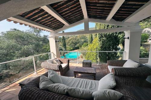 un patio avec un canapé et des chaises sur une terrasse dans l'établissement Villa de caractère! Sereine, piscine, plages 5mns!, à Port Grimaud