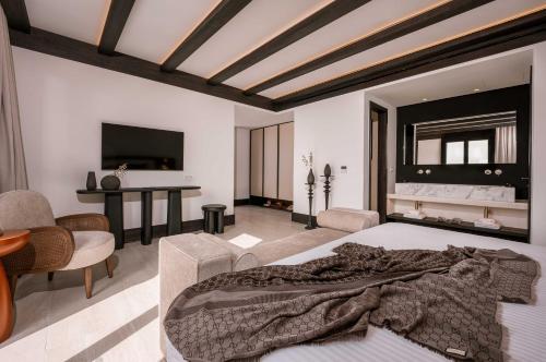 a bedroom with a large bed and a living room at Noir Mykonos in Mýkonos City