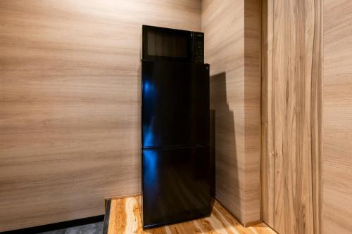 a black refrigerator in the corner of a wall at Itoshima Resort TUMUGU - Vacation STAY 18263 in Fukuoka