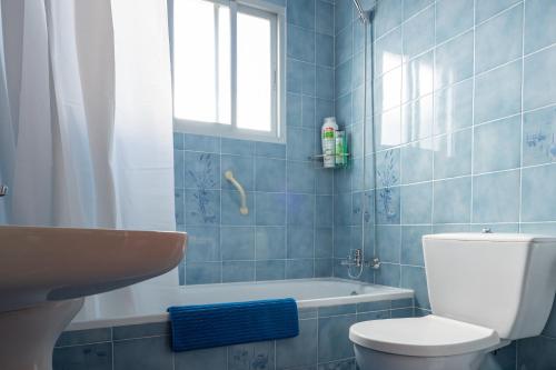 a blue tiled bathroom with a toilet and a sink at Villa Biznaga in Rincón de la Victoria