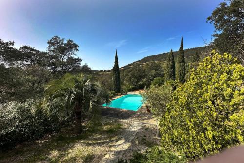 a swimming pool in a garden with trees and bushes at Villa de caractère! Sereine, piscine, plages 5mns! in Port Grimaud