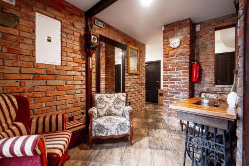 a living room with a chair and a brick wall at APARTMÁNY Prešov 3, Slovenska 92 - 3 in Prešov
