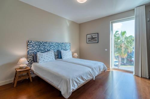 a bedroom with a bed and a large window at Suite 107 in Funchal