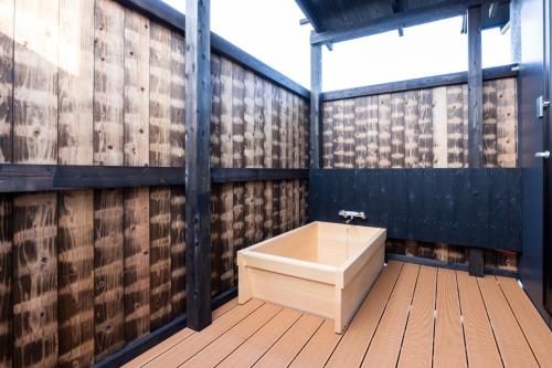 a bathroom with a tub on a wooden deck at Itoshima Resort TUMUGU - Vacation STAY 18230 in Fukuoka