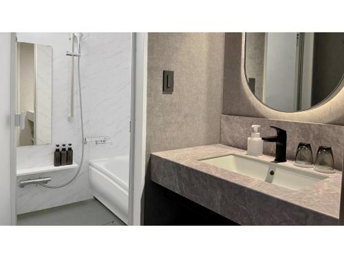 a bathroom with a sink and a tub and a mirror at THE KNOT HIROSHIMA - Vacation STAY 20562v in Hiroshima