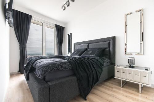 a bedroom with a black bed and a window at Stylish 28F Gym Free Pkg Secured in Skopje