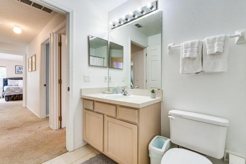 a bathroom with a sink and a toilet and a mirror at Southern Dunes Family Retreat Hot Tub and Game Room in Haines City