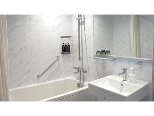 a white bathroom with a tub and a sink at THE KNOT HIROSHIMA - Vacation STAY 32485v in Hiroshima