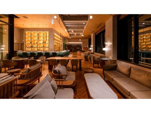 a lobby with couches and tables in a library at THE KNOT HIROSHIMA - Vacation STAY 32485v in Hiroshima