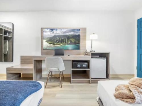 a bedroom with a desk with a tv and a chair at Geary Parkway Motel in San Francisco