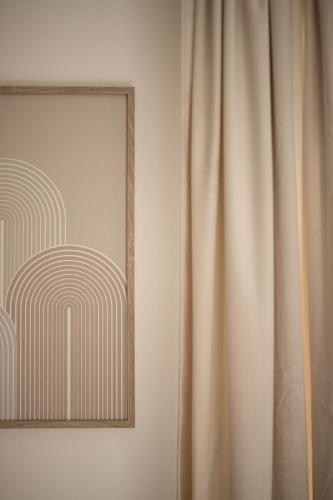 a picture and a curtain next to a mirror at Útulné studio na břehu Lipna in Černá v Pošumaví