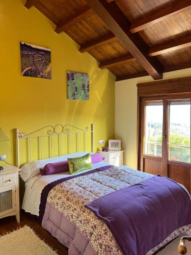 a bedroom with a bed and a yellow wall at Casa El Gabinete in Cariño