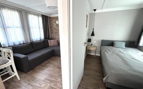 a small apartment with a couch and a bed in a room at Aranypart Apartmanházak Tiszakécske in Tiszakécske