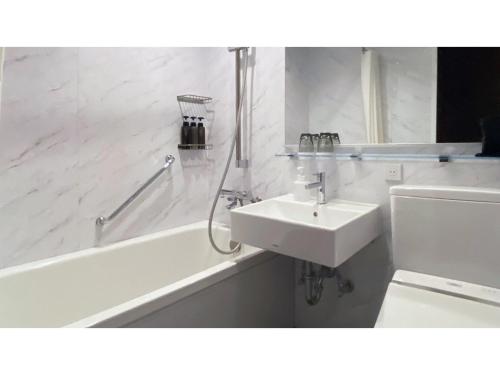a white bathroom with a sink and a bath tub at THE KNOT HIROSHIMA - Vacation STAY 20564v in Hiroshima