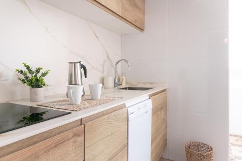 a kitchen with wooden cabinets and a sink at Soleado apartamento en el centro de la ciudad in Santander