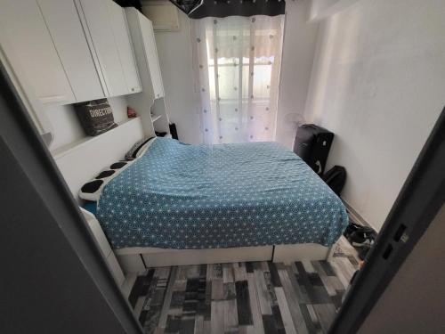 une chambre avec un lit avec une couette bleue dans l'établissement Appartement à 6 minutes à pied de la mer, à Cagnes-sur-Mer
