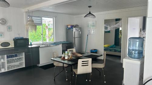 a kitchen with a table and chairs and a refrigerator at LE FARE BLEU Tiputa Rangiroa in Tiputa