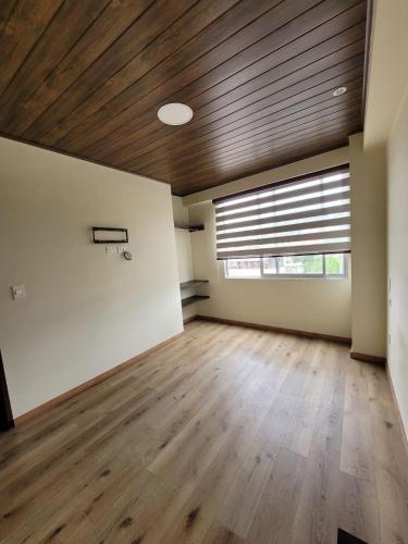 una stanza vuota con un soffitto in legno e un canestro da basket di Beautiful apartment a Sucre