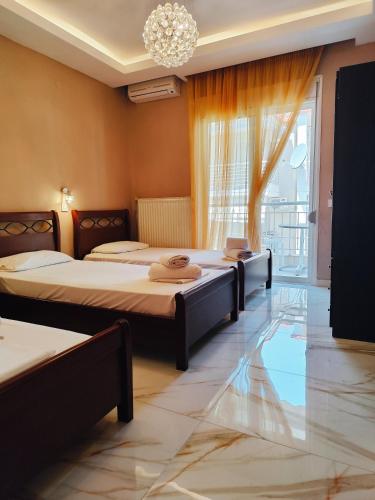 two beds sitting in a room with a window at Althea Studios & Apartments in Hanioti