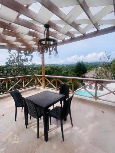einen schwarzen Esstisch und Stühle auf dem Balkon in der Unterkunft Villa para grupos in Concepción de La Vega