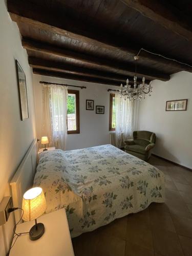 Un dormitorio con una cama grande y una lámpara de araña. en Ai Due Ponti, en Asolo