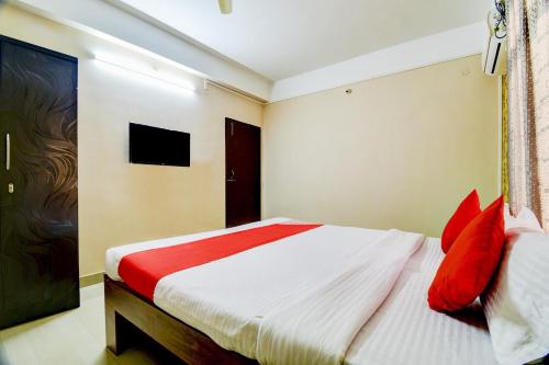 a bedroom with a bed with red pillows at Hotel O The Dove Villa in Dispur