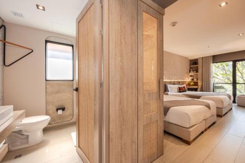 a bedroom with two beds and a bathroom at Landmark Hotel in Medellín