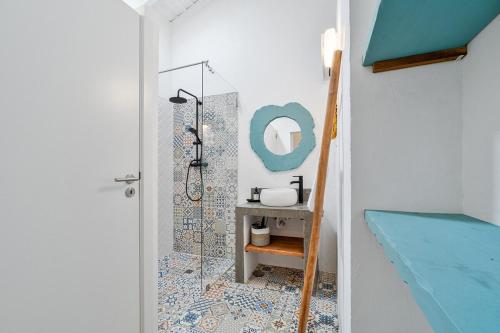 ein Bad mit einer Dusche und einem Waschbecken mit einem Spiegel in der Unterkunft Teal and Green - Alqueva Country House in Amieira