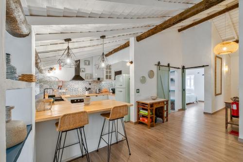 a kitchen with a wooden counter and stools at Teal and Green - Alqueva Country House in Amieira