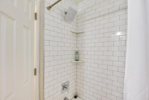 a white tiled shower with a blue soap bottle at 5 Mi to Dtwn Tulsa Pet-Friendly Home! in Tulsa