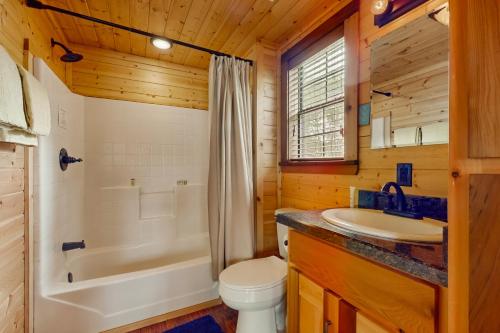 a bathroom with a toilet and a tub and a sink at 4 Cabins - Reindeer Ranch at Round Top in Carmine