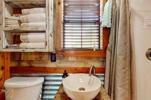 a bathroom with a sink and a toilet and a window at 4 Cabins - Reindeer Ranch at Round Top in Carmine