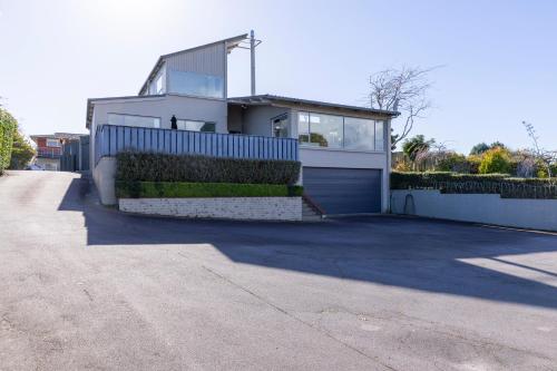 a house with a blue fence and a garage at Sanctuary 53 Beautiful Views in Taupo