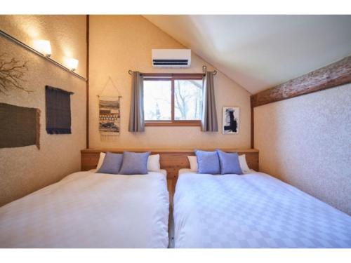two beds in a small room with a window at Fiore Shima - Vacation STAY 25653v in Shima